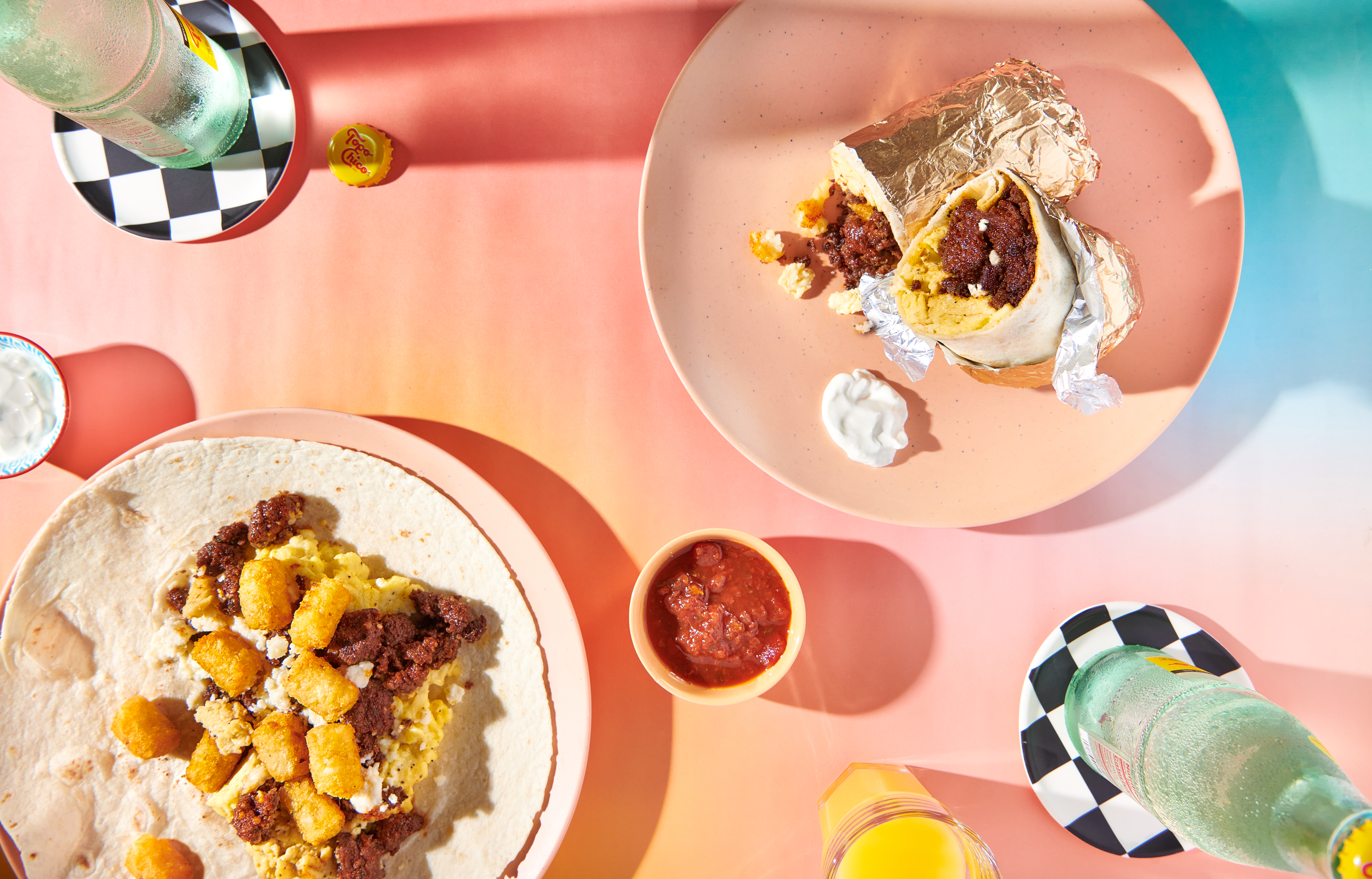 Breakfast burritos served alongside a small bowl of red salsa.